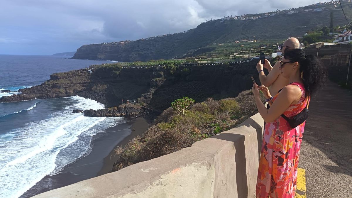 Turistas inmortalizando el lugar en sus móviles tras llegar al acantilado a pie.