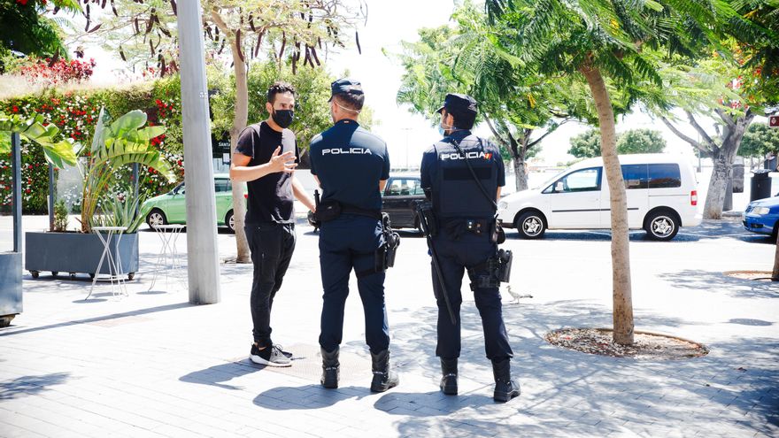 Dos agentes de la Policia Nacional responden a las dudas de un hostelero en Santa Cruz. (Andrea Domínguez)