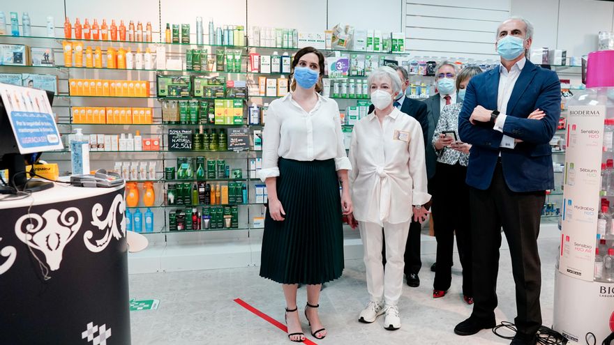 La presidenta de la Comunidad de Madrid, Isabel Díaz Ayuso (1i), acompañada del consejero de Sanidad, Enrique Ruiz Escudero (1d), en una farmacia durante la presentación de la tarjeta sanitaria virtual