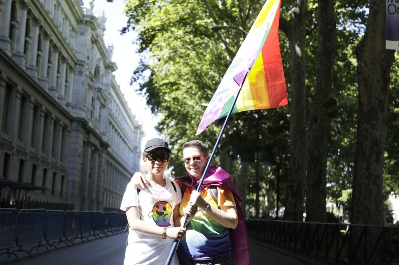 Dos asistentes al Orgullo 2019 sostienen una gran bandera / Marian Leon