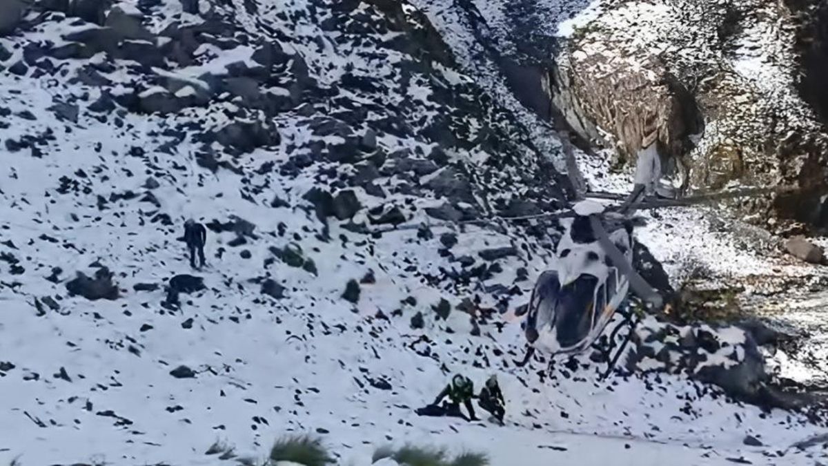 Agentes del Greim y de la Guardia Civil y su helicóptero en unos escarpados y nevados Picos de Europa.