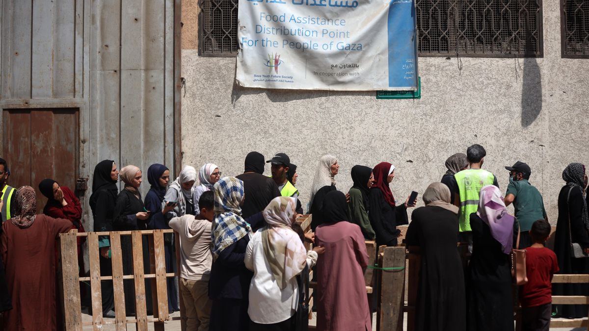 Palestinos hacen cola frente a un punto de distribución de harina