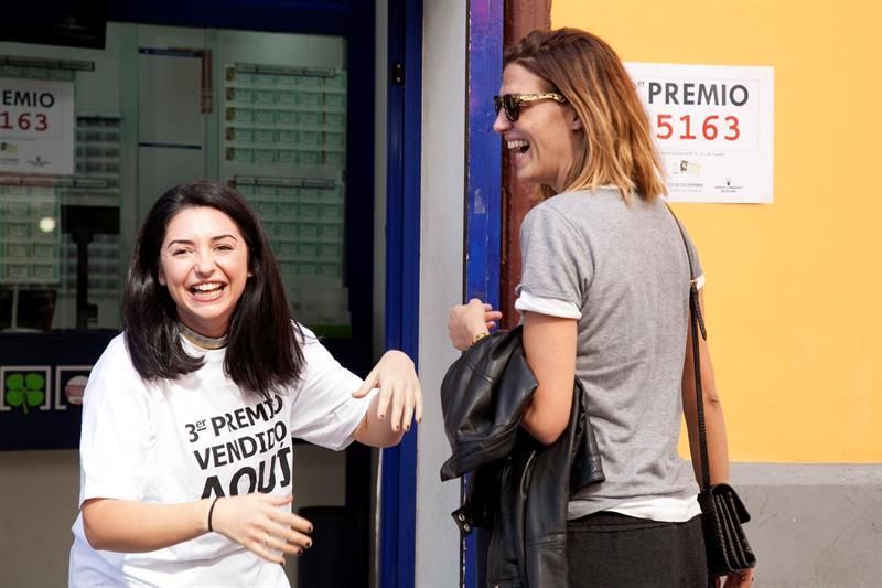 Una empleada de la administración número 9 de Santa Cruz de Tenerife, recibe las felicitaciones de la modelo Laura Sánchez (d), tras conocer que ha vendido por máquina un tercer premio del sorteo de la Lotería de Navidad.