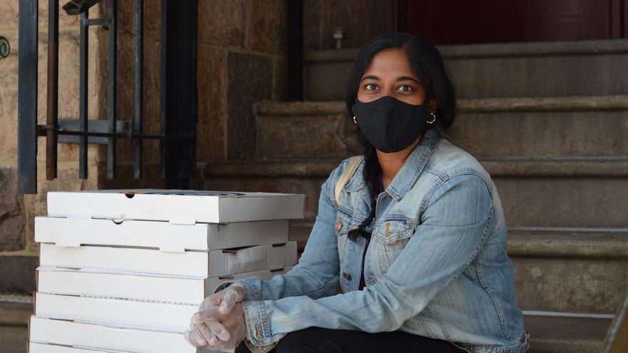 Anita Pandien, voluntaria que forma parte de la organización Pizza to the polls (Pizza a los centros de votación, en español), junto a cajas de pizza.
