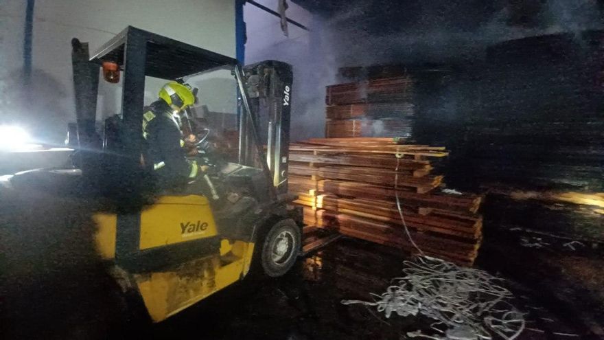 Los bomberos trabajan para apagar un incendio declarado en una nave industrial de maderas en Arinaga
