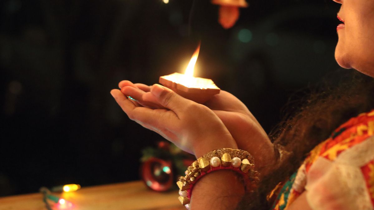 Una mujer sostiene una vela encendida durante la celebración del Diwali.