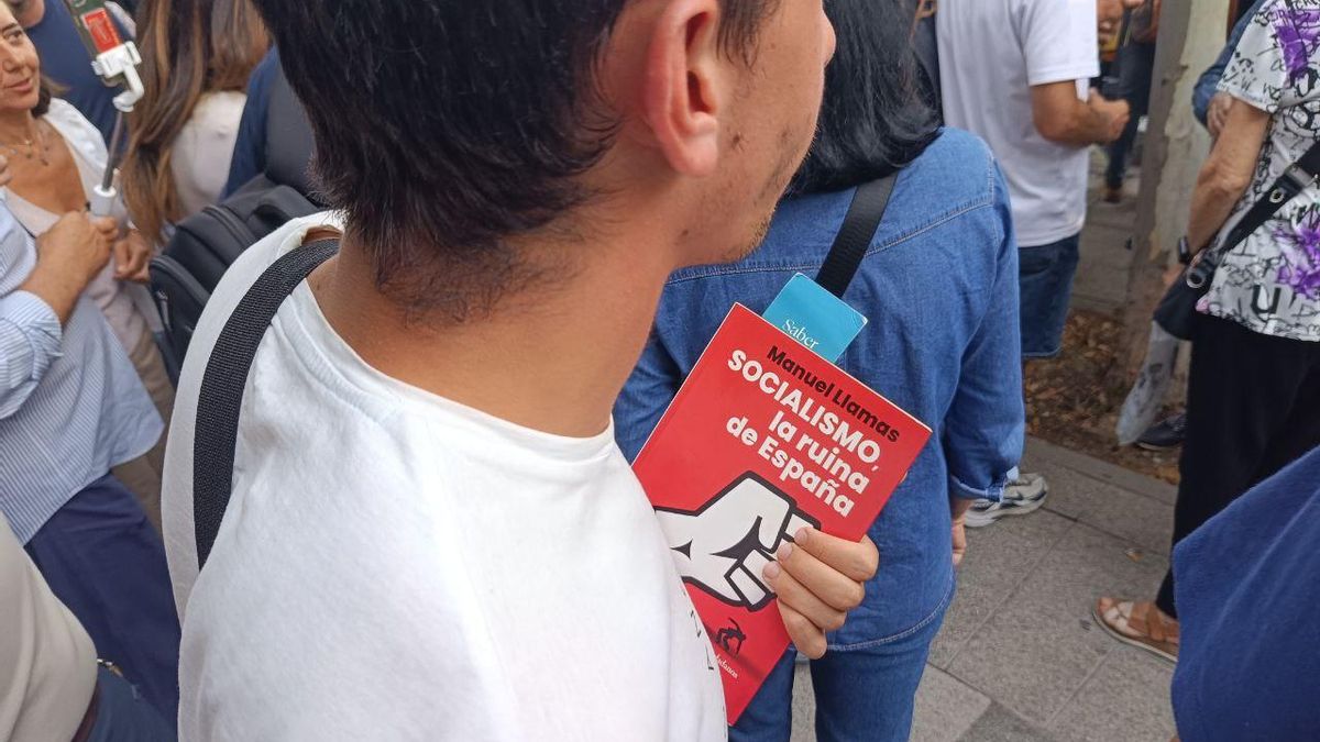 A young man carries the book 'Socialism, the ruin of Spain'