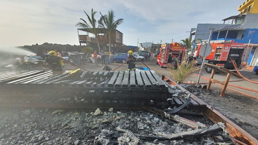 Dos bomberos actuando en la zona donde se ha registrado el incendio de dos embarcaciones en el núcleo costero de La Bombilla en la tarde de este jueves.