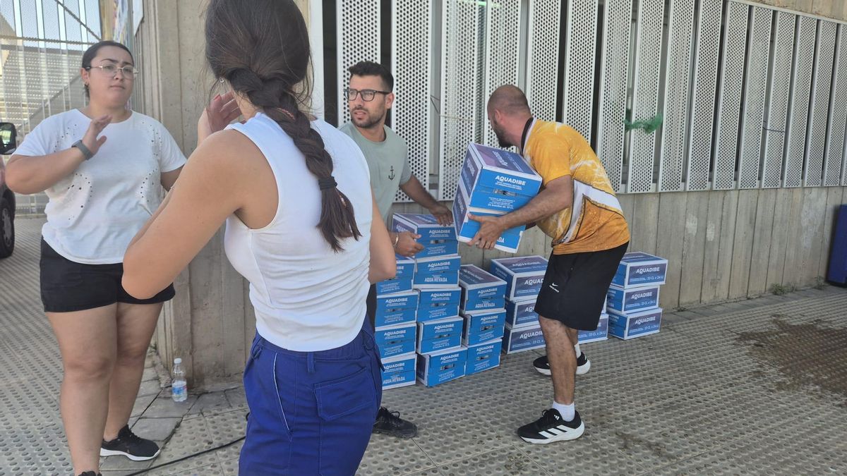 Voluntarios colocan cajas de agua en el exterior del polideportivo Vista Alegre de Garrucha