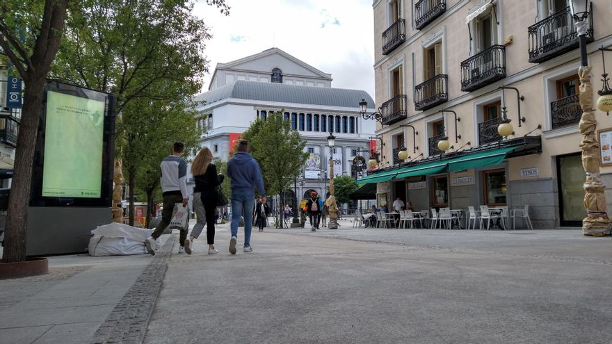 Varias personas pasean por el nuevo pavimento de la calle Arenal camino de Ópera