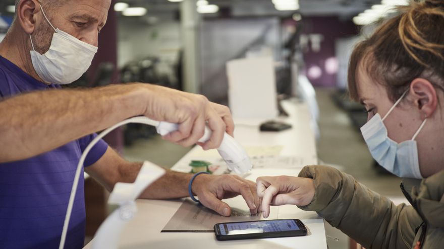 Un trabajador comprueba el pasaporte Covid en un gimnasio
