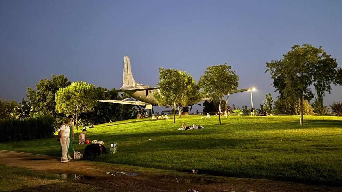 Gente en el césped del Balcón del Guadalquivir en una noche de verano.