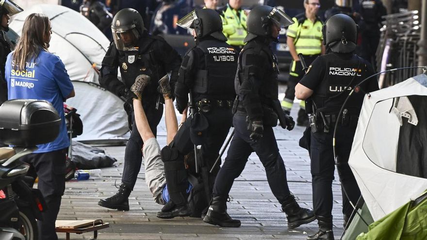 La Policía Nacional saca a ratras a un activista que se ha concentrado este miércoles en la calle del Alcalde Sainz de Baranda, en el madrileño distrito de Retiro, en las proximidades del domicilio donde está previsto el cuarto y definitivo intento de desahucio de Maricarmen, una anciana de 87 años.