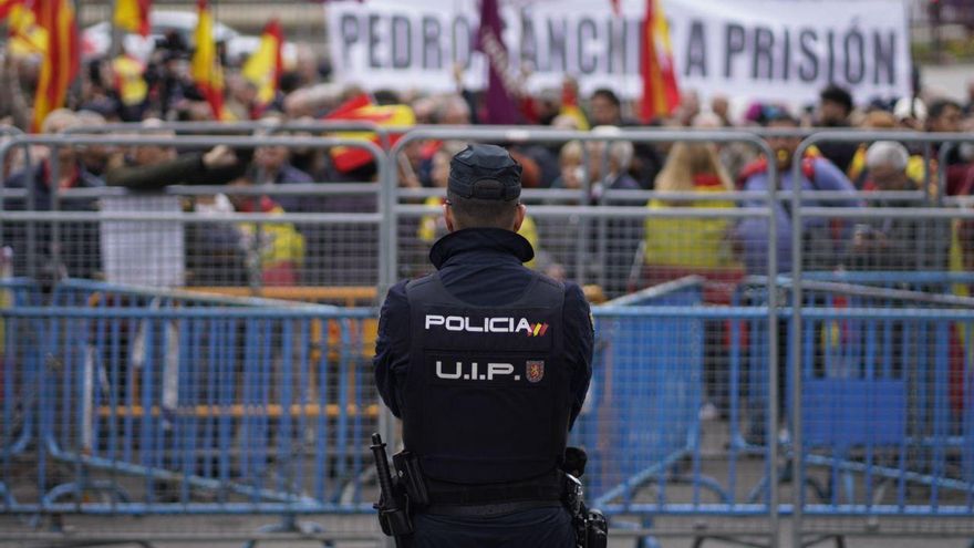 Un agente de Policía observa a los congregados ante el Congreso de los Diputados contra la investidura de Pedro Sánchez