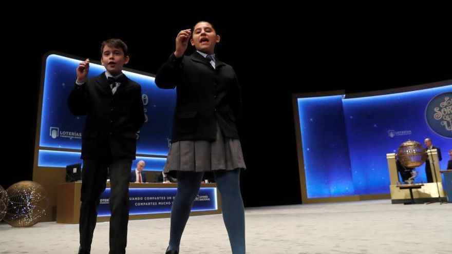 Los niños Nerea Pareja y Luis Alcides muestran las bolas del número 10.989 agraciado con el segundo premio del Sorteo Extraordinario de la Lotería de Navidad que se celebra este domingo en el Teatro Real de Madrid, dotado con 1.250.000 euros a la serie, por lo que el poseedor de cada décimo ganará 125.000 euros.