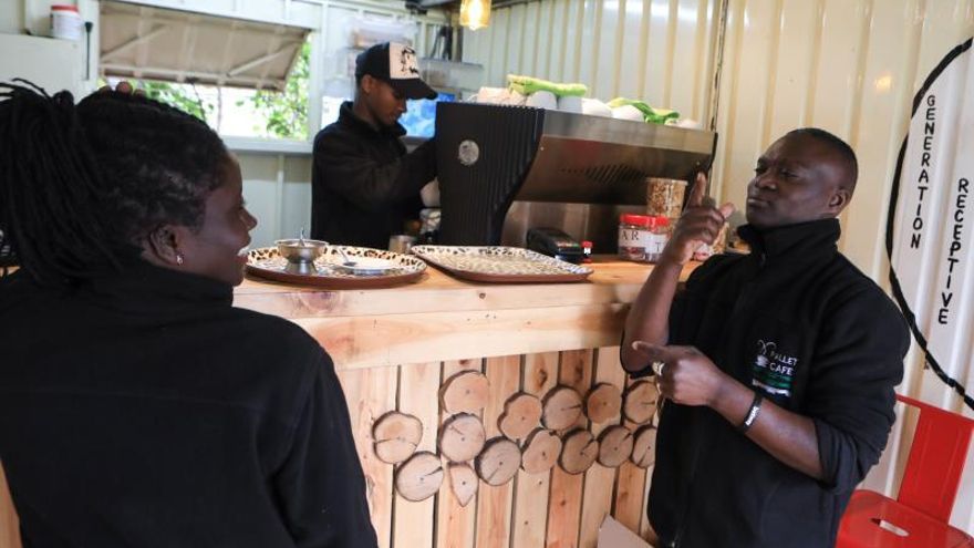 Waiters with hearing impairment Divia Awour (L) and Boniface Odhiambo (R) talk by using sign language as they wait for orders to be processed at the Pallet Cafe in Nairobi, Kenya, 17 July 2019. Five of 15 employees at the Pallet CafE have hearing impairment and they mainly serve as waiters where they use sign languages to serve their customers and teach them basic sign languages to communicate with them. The cafe is one of the few businesses where its hiring policies have given persons living with disability a chance for employment. (Kenia) EFE/EPA/DANIEL IRUNGU ATTENTION: This Image is part of a PHOTO SET