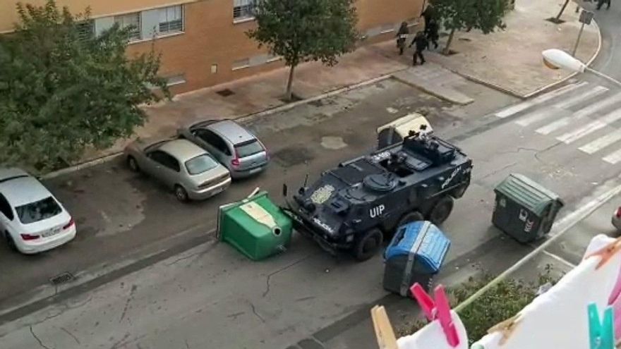 El blindado de la policía arrastra varios contenedores en en la barriada del Río San Pedro en Puerto Real, Cádiz.