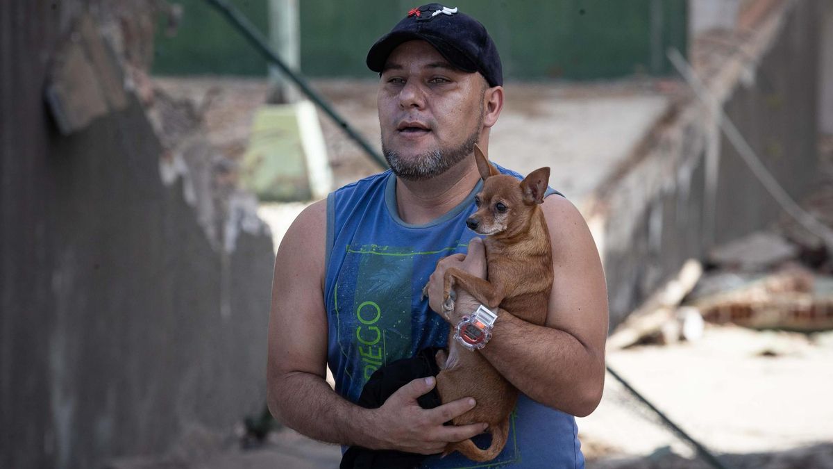 Un hombre carga una mascota rescatada tras los terremotos en Caracas