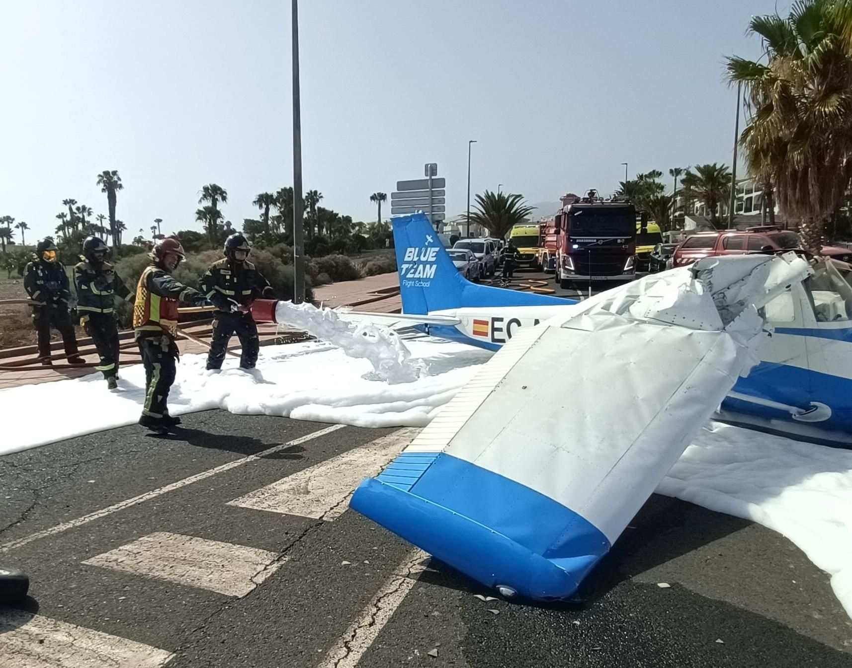 Bomberos de Tenerife vierten espuma en el lugar del accidente de una avioneta en plena calle en el sur de Tenerife.