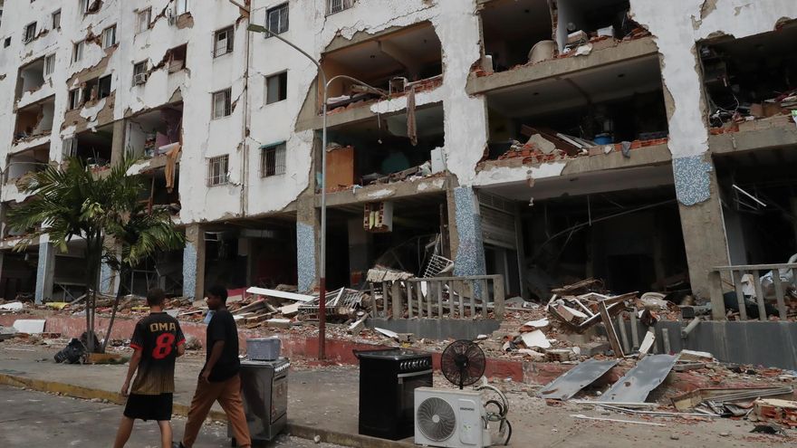 Personas caminan frente a edificios afectados por los terremotos ocurridos en la zona de Caraballeda, en La Guaira (Venezuela).