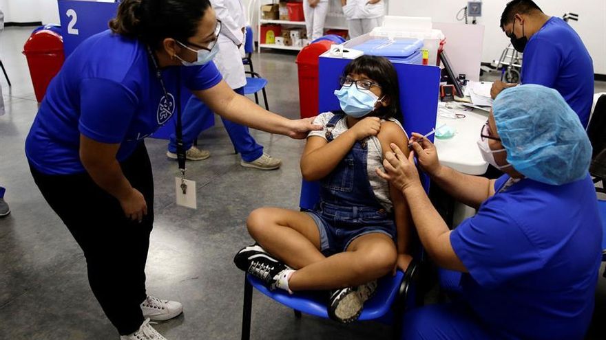 Una niña reacciona al recibir su primera dosis de la vacuna contra la covid-19, hoy, en el centro de vacunación del Hospital El Salvador, en San Salvador. Personal del Ministerio de Salud (Minsal) de El Salvador comenzó este miércoles con la vacunación contra la covid-19 a menores de entre 6 y 11 años, en momentos en que se registra en el país un alza en la cifra de casos diarios.