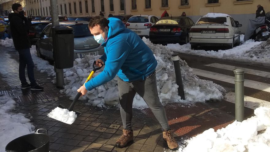 Un vecino de Chamberí quita el hielo acumulado tras la nevada.