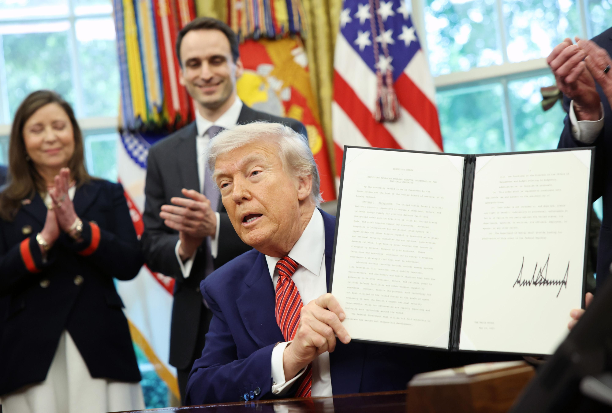 Trump muestra una orden ejecutiva recién firmada en el Despacho Oval
