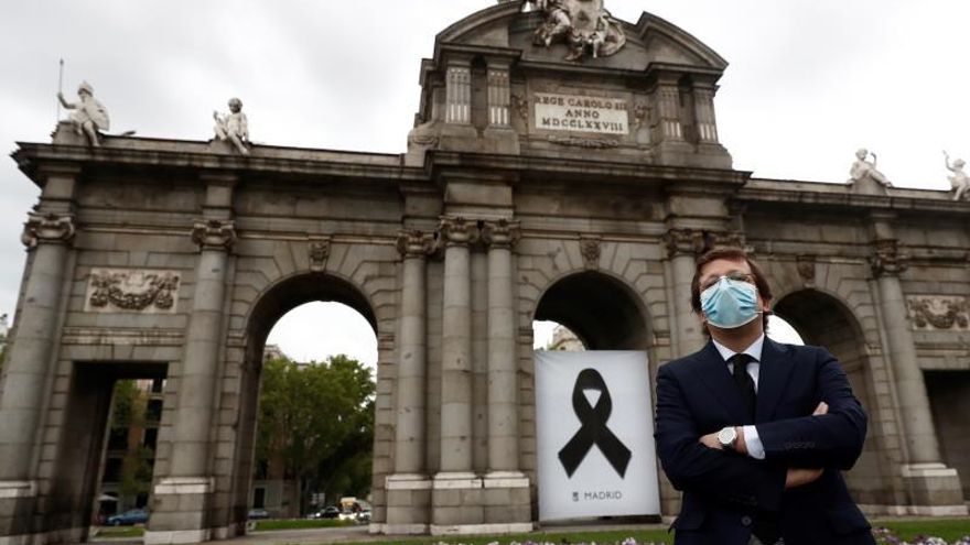 El alcalde de Madrid, José Luis Martínez-Almeida, junto a la Puerta de Alcalá, este jueves, en Madrid, donde se ha descubierto un crespón negro y se ha guardado un minuto de silencio por los fallecidos con coronavirus.