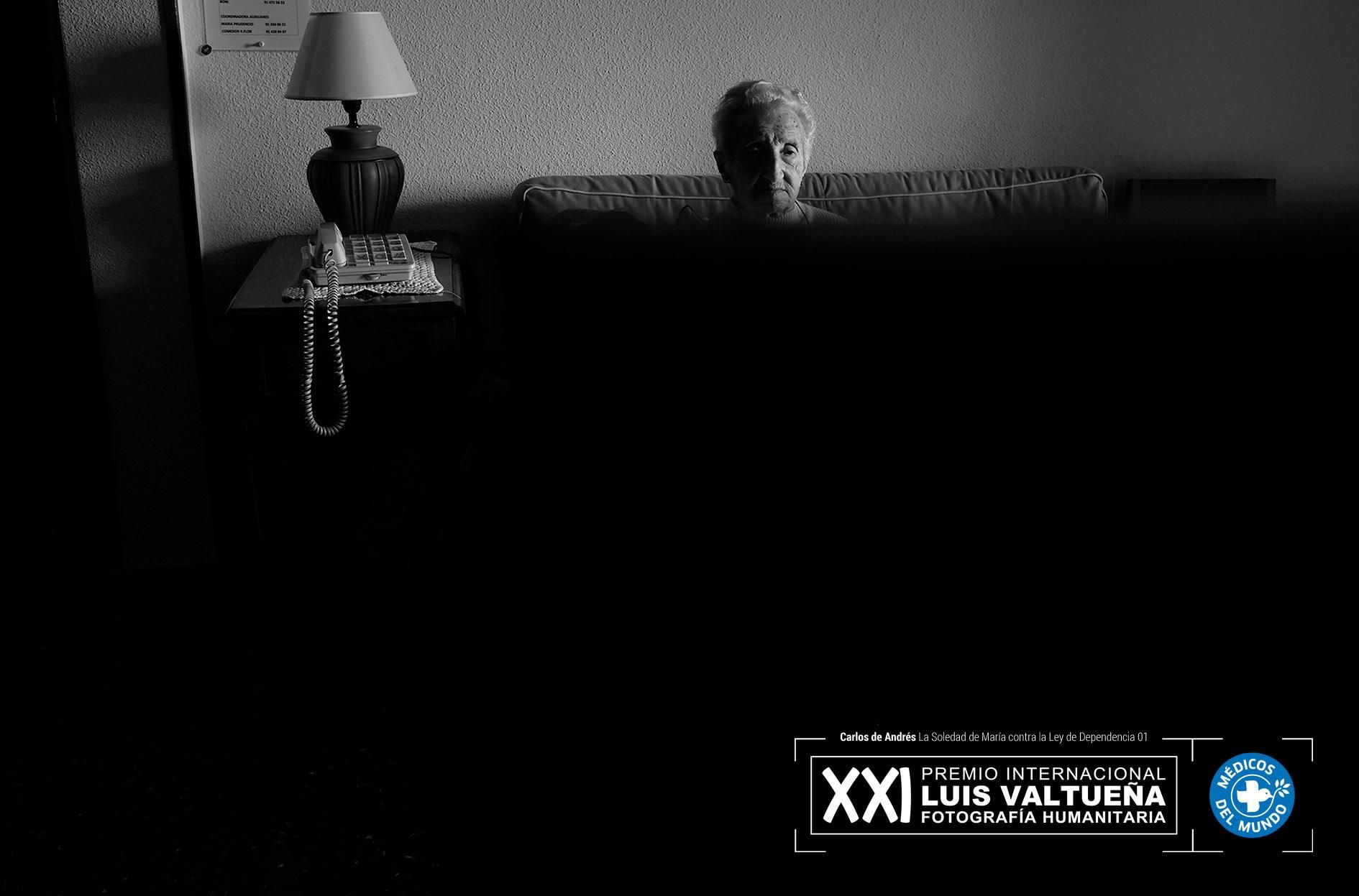 María ve la televisión en el salón de casa.  Foto: Carlos de Andrés. Ganador del XXI Premio Internacional de Fotografía Humanitaria Luis Valtueña de Médicos del Mundo. 2017-2018