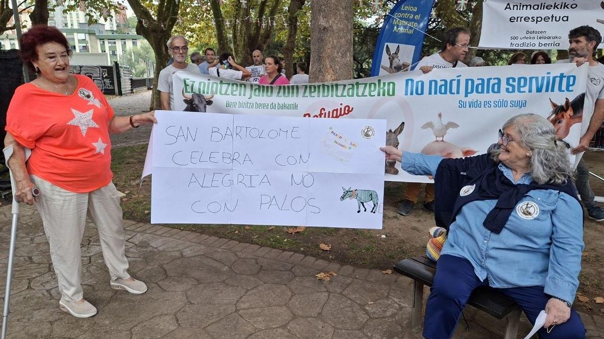 Vecinas de Leioa muestran un dibujo hecho por los niños del barrio contra el maltrato a los burros en las Asto Probak