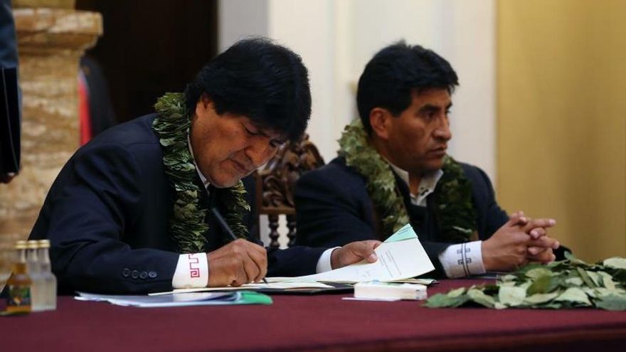 El presidente de Bolivia, Evo Morales (i), acompañado del ministro de Desarrollo Rural y Tierras, Cesar Cocarico (d), firma la Ley de la Coca el 8 de marzo de 2017, en La Paz (Bolivia).