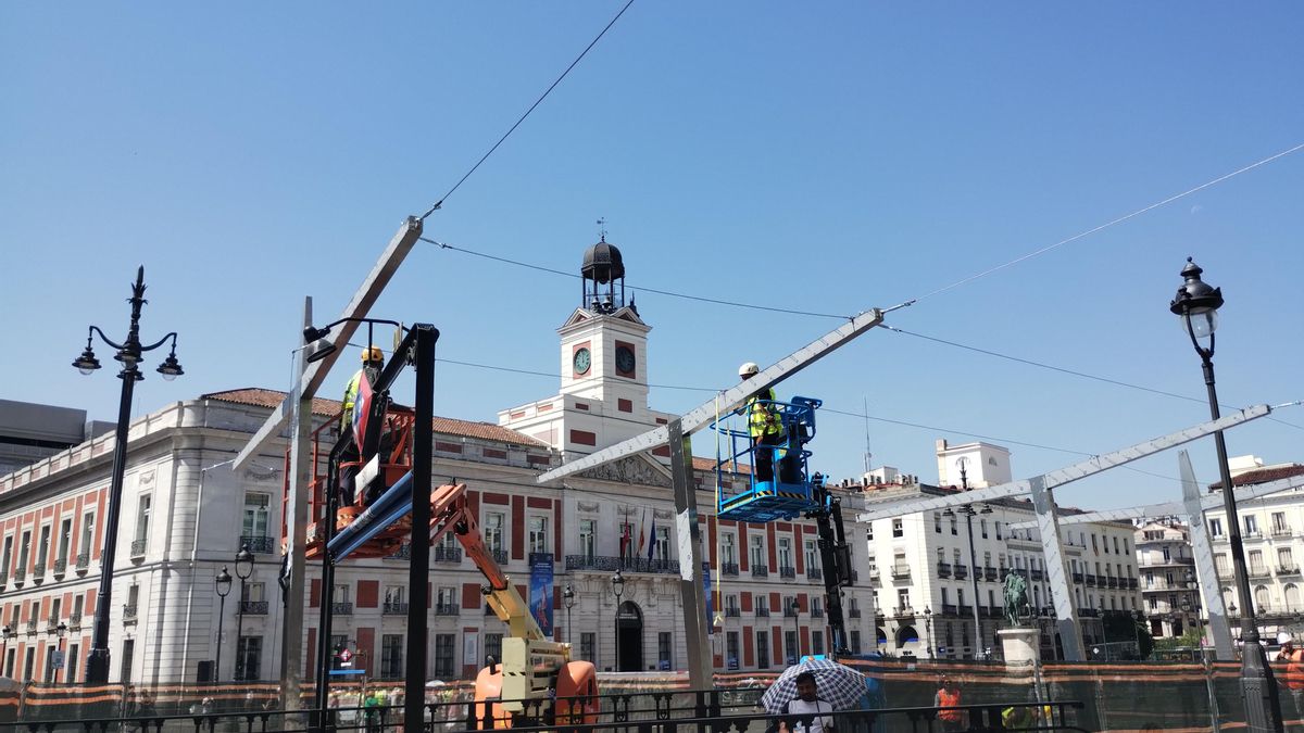 Vista de las estructuras metálicas con las guías para colocar los toldos, mientras los operarios trabajan