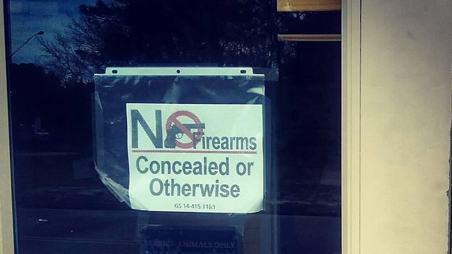 Un cartel en la entrada de la sede de Tráfico en una ciudad de Carolina del Norte recuerda que no se puede entrar con armas 