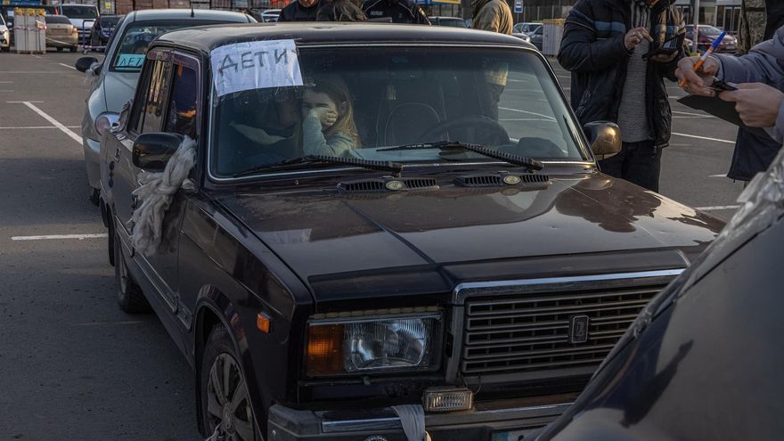 A child sits in a car with a note that reads 'children' as she with other people who fled from the besieged by Russian military southeastern city of Mariupol and occupied Melitopol arrive at the evacuation point in Zaporizhzhia, Ukraine, 25 March 2022.