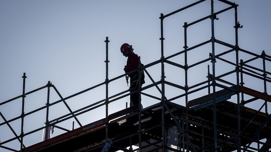 Archivo - Una persona subida a un andamio