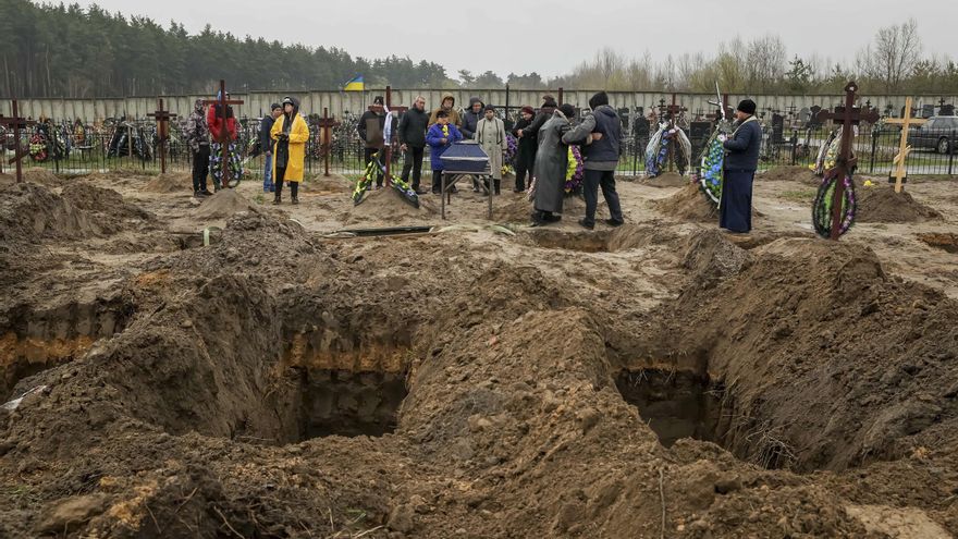 Varias personas asisten a un entierro en el cementerio de Bucha (Ucrania) . EFE/Miguel Gutiérrez