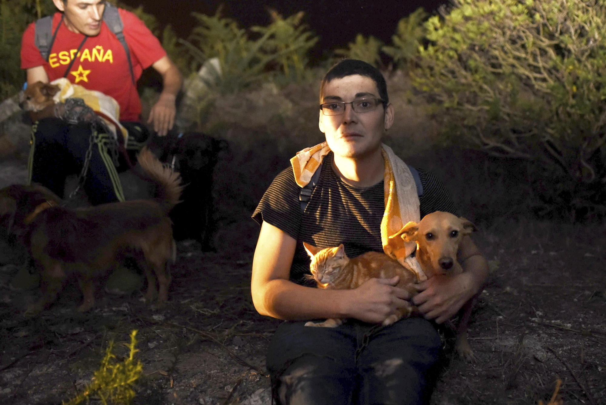 Los residentes sostienen a sus mascotas mientras un fuego salvaje avanza sus casas en As Neves, Pontevedra, Galicia.