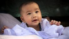 Bebé asiático con gesto sonriente