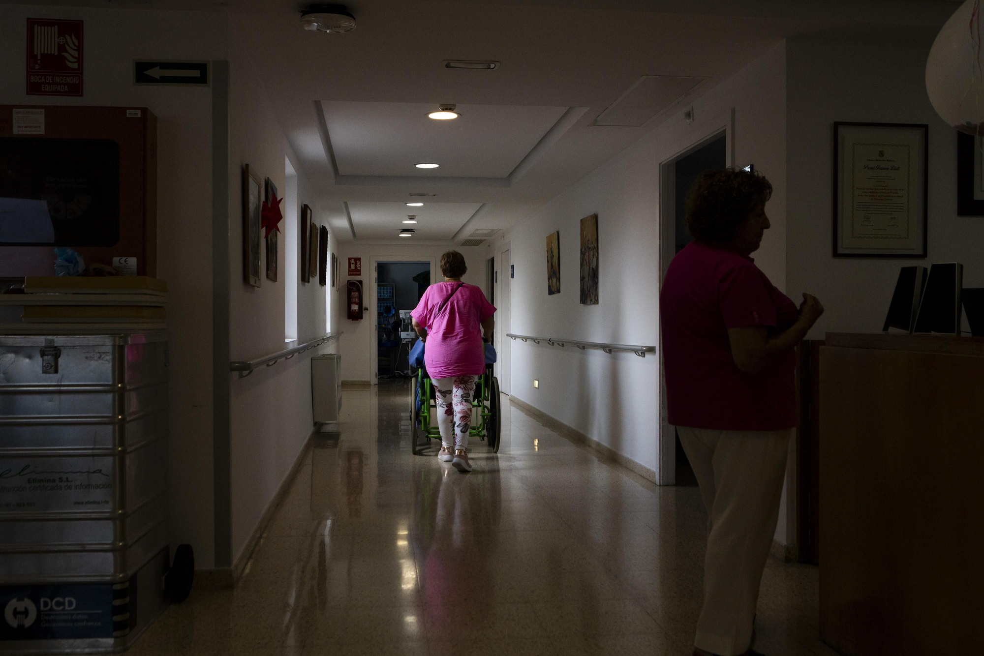 Una mujer traslada a un paciente a su habitación