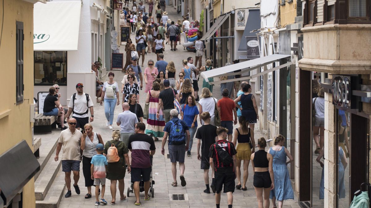 Un grup de persones camina pels carrers de Maó.