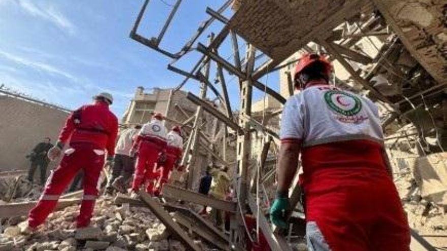 Trabajadores de la Media Luna Roja de Irán examinan destrozos tras un ataque.