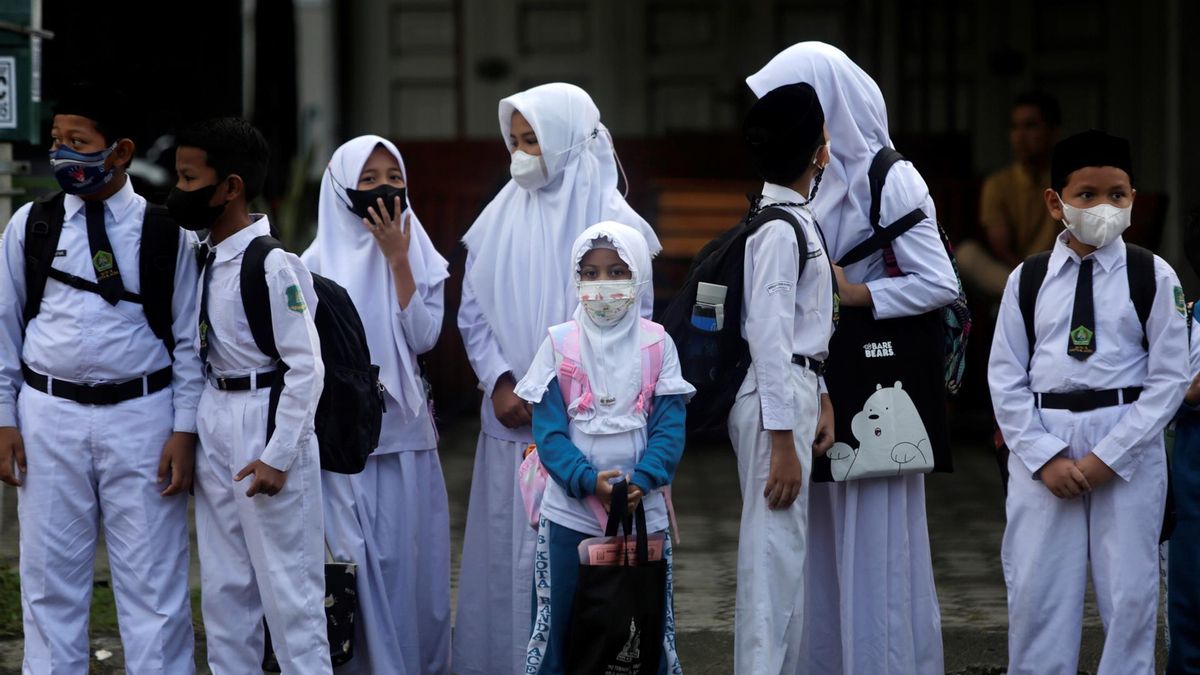 Banda Aceh (Indonesia), 08/02/2022.- School students wear protection masks as one of the requirements to be able to take part in face-to-face lessons for school in Banda Aceh, Indonesia, 08 February 2022. The Indonesian government decided to extend the enforcement of public activity restrictions to level 3 following the significant increase in Covid-19 Omicron variant cases, with a peak in infections estimated by the end of February 2022.