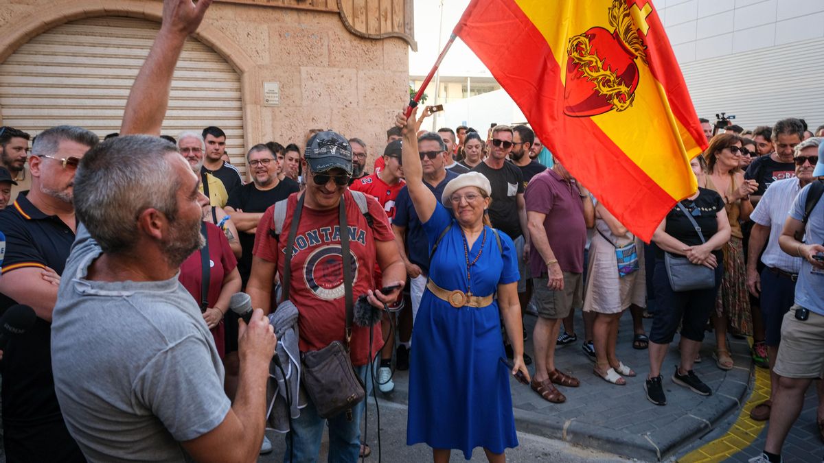 Una mujer vestida de azul y con una bandera del corazón de jesús, durante la protesta organizada por colectivos ultras en Torre Pacheco