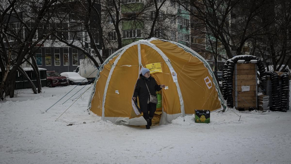 Una mujer sale de una caseta hinchable naranja utilizada para contrarrestar la crisis energética en Kiev.