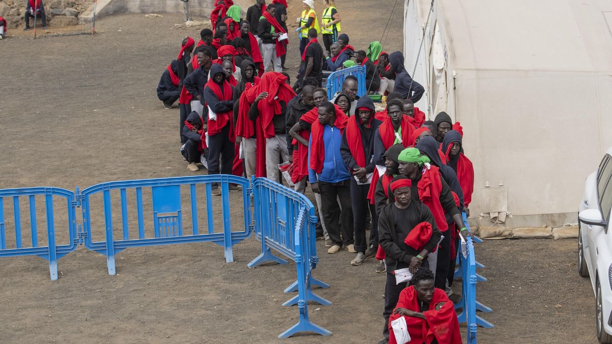 Archivo - Varios migrantes esperan para ser trasladados al puerto de La Estaca