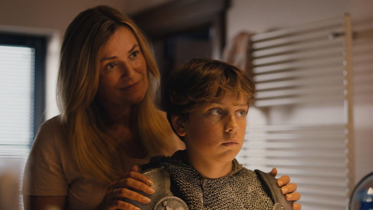 La madre (Emilie de Roo) preparando a su hijo para un baile de disfraces