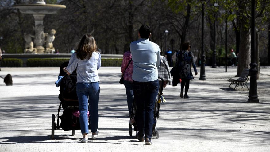 Unos padres pasean a sus hijos en sillitas de bebé. Marzo de 2020.