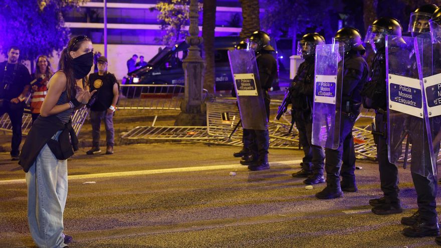 Una joven frente a la policía durante la manifestación convocada por el Sindicat de Llogateres de Catalunya y el Sindicat d’Habitatge Socialista de Catalunya frente al lugar donde se celebra un acto al que asiste el presidente de Gobierno, Pedro Sánchez, para reclamar el 'decreto Maricarmen'.