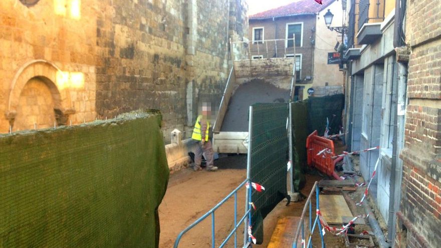 Los operarios, extendiendo la capa de hormigón que habrá de sustentar el nuevo suelo de losetas.