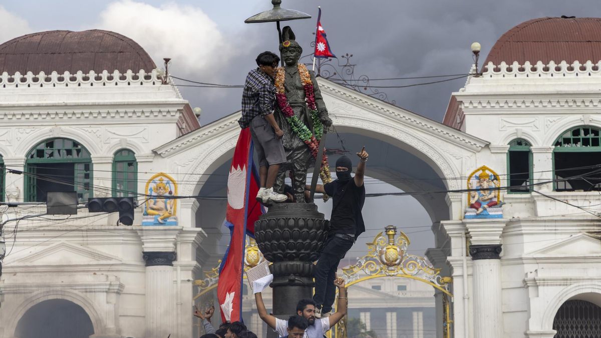 Manifestantes cuelgan la bandera nacional sobre el primer rey de Nepal, Prithvi Narayan Shah